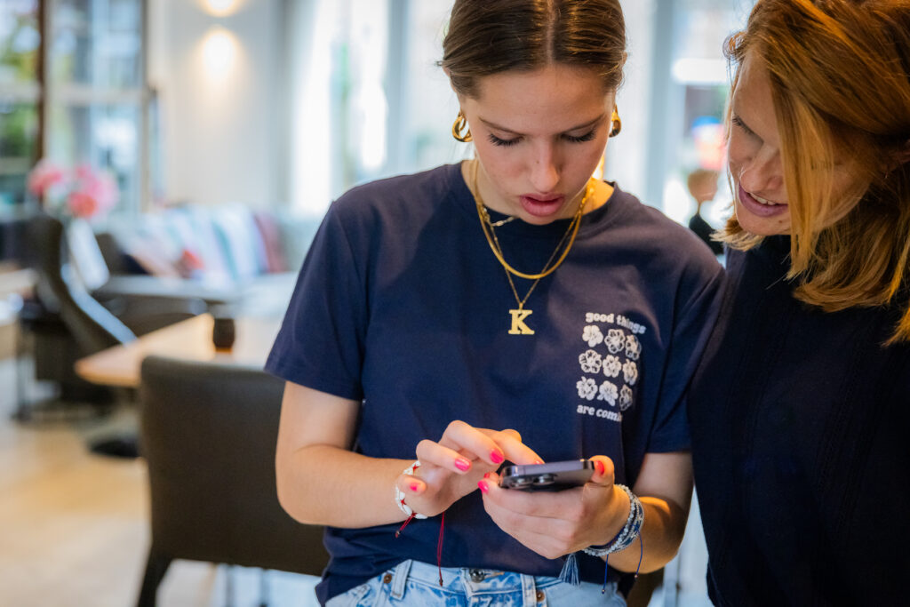 moeder en dochter kijken naar mobiele telefoon